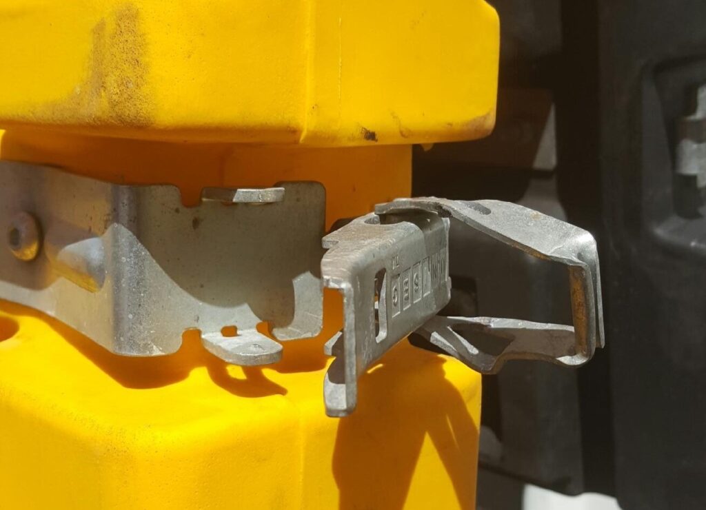 Photo showing damaged over centre latch on a collapsible bulk container